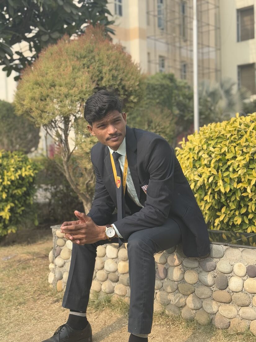 In a suit, seated in a garden